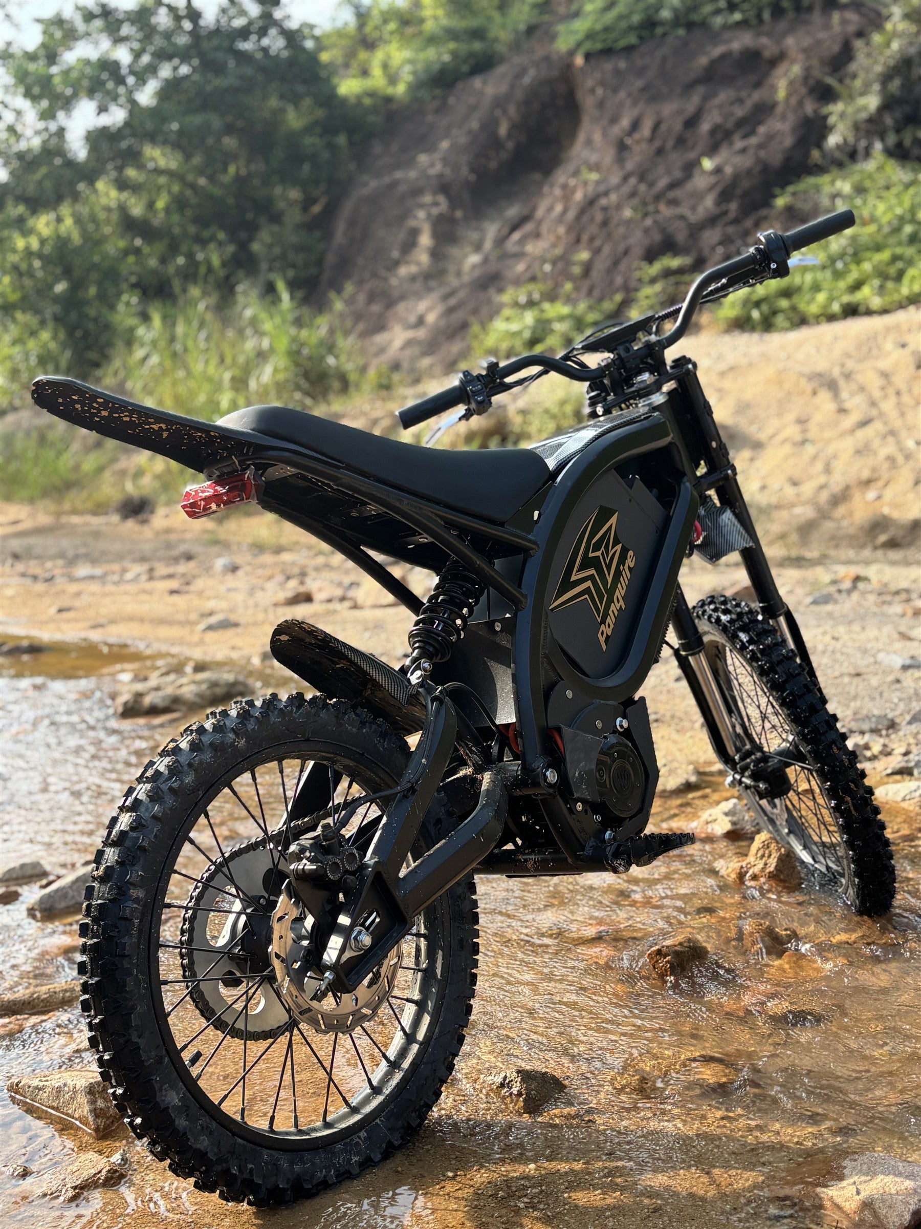 Panquire electric motorcycle in a rocky stream